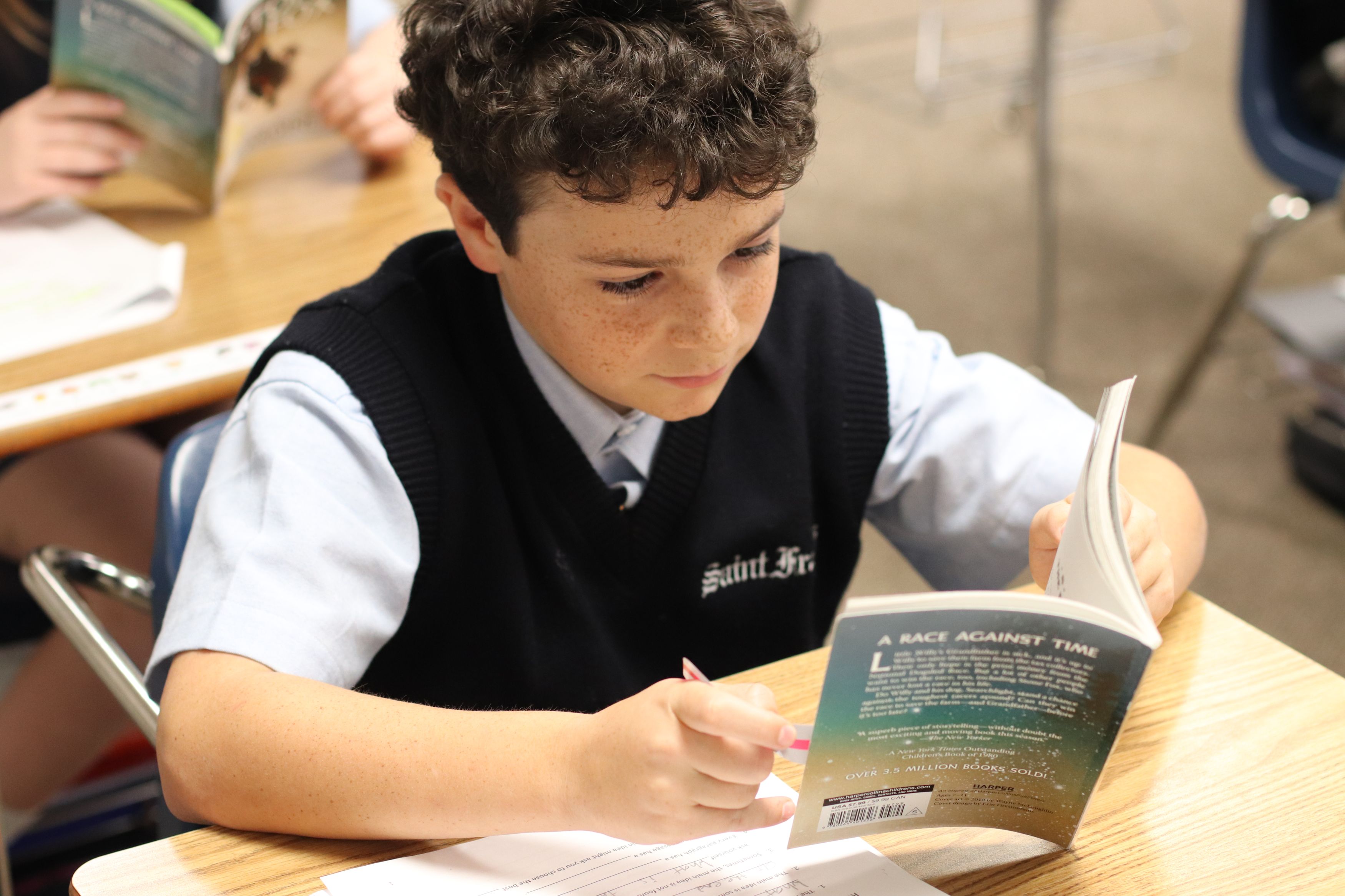 Saint Francis Middle School student reading and working